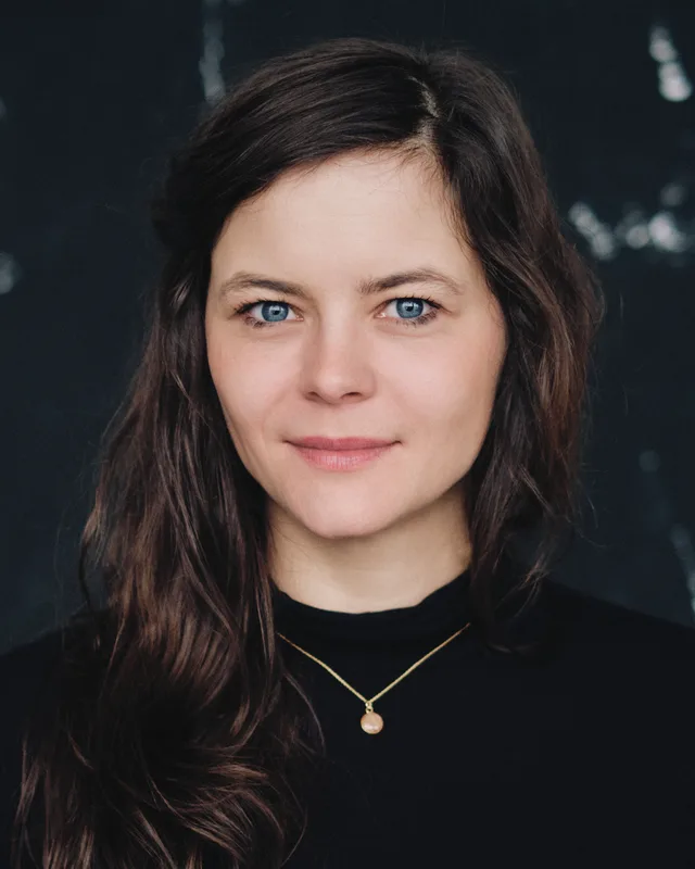 Susanne Aßmann, Porträt frontal vor dunklem Studiohintergrund